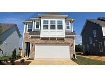Charming two-story home with brick and blue siding and a spacious two-car garage at 98 Willow Cameron Way, Angier, NC 27501