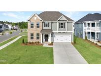 Charming two-story home featuring a two-car garage, well-manicured lawn, and classic architectural details at 15 Nimble Way # 175, Clayton, NC 27520