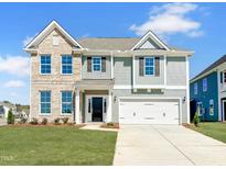 Two-story home featuring a mix of brick and siding, a well-manicured lawn, and an attached two-car garage at 15 Nimble Way # 175, Clayton, NC 27520