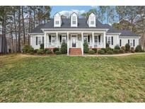 Charming home featuring a welcoming front porch, landscaped lawn, and classic architectural details at 19 Juneberry Pl, Clayton, NC 27527