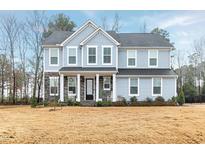 Charming two-story home with light-blue siding and stone accents, offering classic curb appeal at 213 W Weatherford Dr, Angier, NC 27501