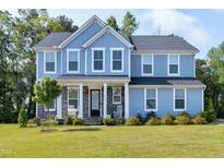 Charming two-story home featuring blue siding, stone accents, and a welcoming front porch at 213 W Weatherford Dr, Angier, NC 27501