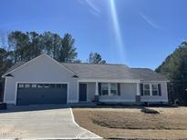 Charming single-story home featuring a gray exterior and a well-manicured front yard at 223 Magnolia Run Way, Benson, NC 27504