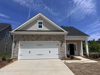 Charming single-story home featuring stone accents, a two-car garage, and a well-manicured front yard at 235 Meadowbark Bnd # 26, Garner, NC 27529