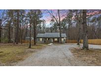 Charming home featuring a gravel driveway and a cozy front porch, surrounded by mature trees at 4082 Old Franklinton Rd, Franklinton, NC 27525