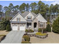 Charming home with a stone facade, manicured landscaping, and a two-car garage at 432 Nickel Creek Cir, Cary, NC 27519