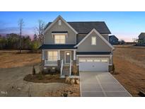 Charming two-story home featuring a covered porch, attached garage, and neutral exterior paint at 44 Belmont Stakes Ln, Wendell, NC 27591