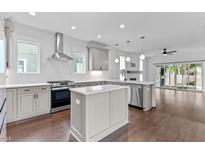 Bright kitchen featuring an island, modern stainless steel appliances, and seamless access to the living room with fireplace at 5 Bart St, Raleigh, NC 27610