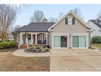 Charming home featuring a blend of brick and siding, a welcoming front porch, and well-maintained landscaping at 610 Brownstone Rd, Gibsonville, NC 27249