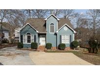 Charming two-story home with a blue exterior, well-manicured landscaping, and a concrete driveway at 886 Drogheda Pl, Wake Forest, NC 27587