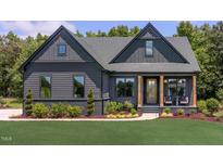 Stunning exterior elevation of a modern farmhouse with dark siding, beautiful landscaping, and a welcoming front porch at Tbd Hudson Hills Rd, Pittsboro, NC 27312