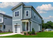Charming two-story home features a modern garage and a stylish front door with visible house number at 136 E End Ave # 4, Durham, NC 27703