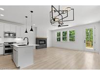 Bright, open living space with a fireplace, modern lighting, light wood floors, and access to a deck at 140 E End Ave # 2, Durham, NC 27703