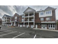 Brick exterior of building with double balconies and ample parking spaces at 1400 Gathering Park Cir # 202, Cary, NC 27519