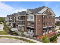 Stunning three-story brick condo building with balconies, awnings, and manicured landscaping at 1400 Gathering Park Cir # 204, Cary, NC 27519