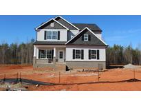 New construction two-story home showing light siding, a brick foundation, and black trim under a bright blue sky at 1415 Reading Ct # 77Kl, Burlington, NC 27217