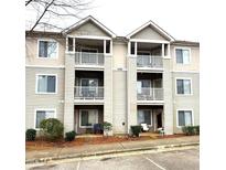 Charming condo exterior featuring double balconies and neutral siding at 1430 Collegiate Cir # 102, Raleigh, NC 27606