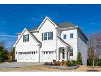 Stunning two-story home featuring a three-car garage and a bright white painted brick facade at 1905 Edgelake Pl, Cary, NC 27519