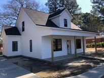 Charming white two-story home with a welcoming front porch and dark-framed windows at 412 N Green St, Selma, NC 27576