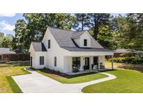 Charming two-story white home featuring a welcoming front porch and freshly manicured lawn at 412 N Green St, Selma, NC 27576