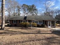 Charming single-story brick home featuring a well-maintained lawn and mature trees at 714 W J St, Erwin, NC 28339