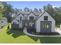 Charming two-story home with gray accents, manicured lawn and a winding walkway at 7412 Wexford Woods Ln, Wake Forest, NC 27587