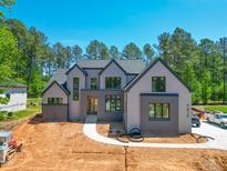 Stunning new two-story home featuring a modern gray color scheme and manicured landscaping at 7412 Wexford Woods Ln, Wake Forest, NC 27587