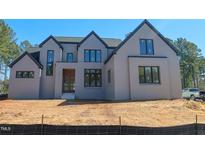 Elegant two-story home boasting a gray brick facade, black roof, and expansive windows at 7412 Wexford Woods Ln, Wake Forest, NC 27587