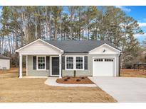 Charming single-story home with a covered porch, gray siding, black shutters, and an attached garage at 100-A Pace St, Smithfield, NC 27577