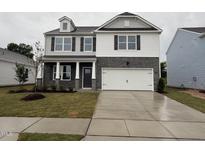 Two story home with a brick and siding exterior, attached garage, and well maintained front lawn at 139 Ethel Ln, Angier, NC 27501