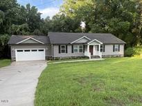 Charming ranch-style home with a well-manicured lawn and an attached two-car garage at 1516 Bragg St, Sanford, NC 27330