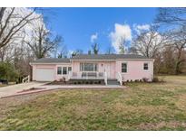 Charming pink home with a cozy front porch and well-manicured lawn, offering inviting curb appeal at 1904 N Ashland Dr, Burlington, NC 27217