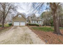 Charming home featuring a two-car garage and a welcoming front porch, surrounded by mature trees at 2010 Twin Acres Rd, Clayton, NC 27520