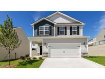 Charming two-story home featuring a gray exterior, black shutters, and a spacious two-car garage at 266 Hanging Elm Ln, Fuquay Varina, NC 27526