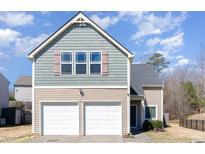 Two-story home featuring a two-car garage and stylish light green and beige exterior at 5627 Quitman Trl, Raleigh, NC 27610