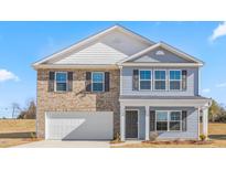 Charming two-story home featuring a mix of brick and siding, a two-car garage, and a welcoming front porch at 864 Forth Ct # 150, Gibsonville, NC 27249