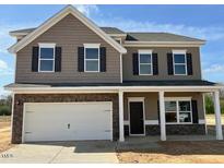 Two-story home boasts attached two-car garage, covered front porch, neutral siding and trim, and black shutters at 88 E Victory View Ter, Smithfield, NC 27577