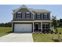 Charming two-story home featuring a stone-accented facade, a white two car garage, and manicured front lawn at 88 E Victory View Ter, Smithfield, NC 27577