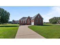 Charming brick home featuring a well-manicured lawn and a long, winding driveway at 105 Pinecrest Dr, Angier, NC 27501
