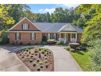 Beautiful brick home with a manicured lawn and landscaping, complimented by a winding driveway at 10937 Cahill Rd, Raleigh, NC 27614