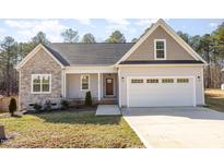 Charming home with a stone facade, a welcoming front porch, and an attached two car garage at 110 Lilac Dr, Franklinton, NC 27525