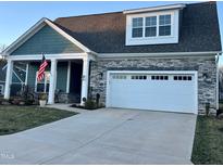 Charming home exterior boasts stone accents, a two-car garage, and a manicured lawn at 1113 Hudson Dr, Mebane, NC 27302