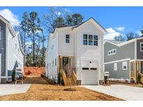 Charming two-story home boasts a modern design and inviting curb appeal with well-manicured landscaping at 1215 Chaney Rd, Raleigh, NC 27606
