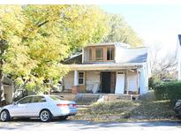 Shows a two-story home with a porch, new windows upstairs, and a car parked on the side of the house at 1404 Gearwood Ave, Durham, NC 27701