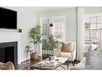 Bright living room featuring a fireplace, stylish decor, and an open view to the dining area at 2204 Guess Rd, Durham, NC 27705