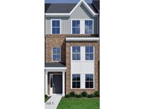 New construction townhome featuring a brick and siding exterior with large windows and a covered entry at 356 Chesapeak Commons St # 135, Garner, NC 27529