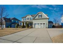 Charming two-story home with a well-manicured lawn, long driveway, and inviting curb appeal on a sunny day at 416 Granite Saddle Dr, Rolesville, NC 27571