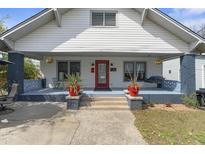 Charming home with a lovely front porch featuring a swing and a red door at 709 North St, Durham, NC 27701
