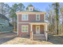 Charming two-story home featuring a welcoming front porch and neutral brown color palette at 717 Heidelberg St, Durham, NC 27704