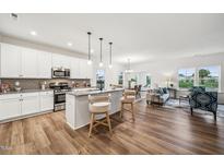 Bright, open kitchen featuring stainless steel appliances, a center island with seating, and wood flooring at 149 Cribbs Ln, Middlesex, NC 27557